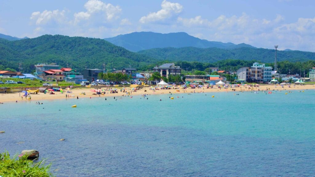 Families enjoy the clear waters of Chodo Beach, with its sandy shores framed by seaside hotels and restaurants.