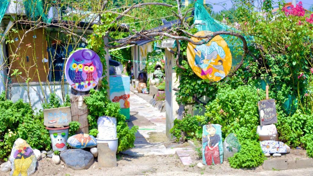 The entrance to a house near Gajin Port is adorned with colorful murals, painted rocks, and an assortment of trinkets.