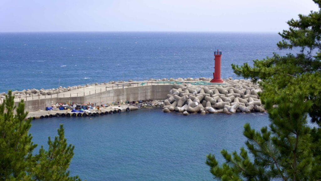 A picture of a lighthouse and breakwater at Nomul Port (노물항) in Yeongdeok County, South Korea.