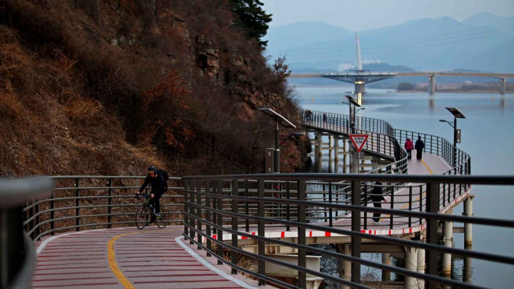 A picture of a raised cycling path that leads to Gangjeong Goryeong Weir (강정고령보) along the Nakdong River in Daegu, South Korea.