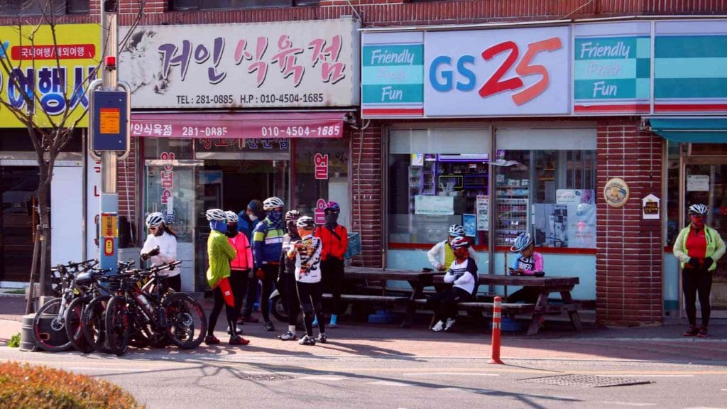 A group of cyclists top at a GS25 convenience store for refreshments.