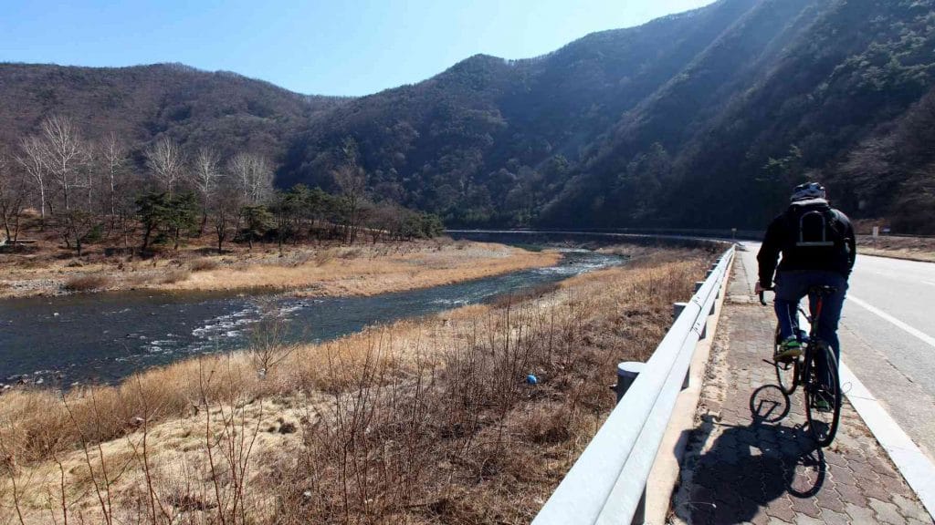 A picture of a cyclists riding the roads of the Jinnamgyoban Area in Mungyeong City, South Korea.