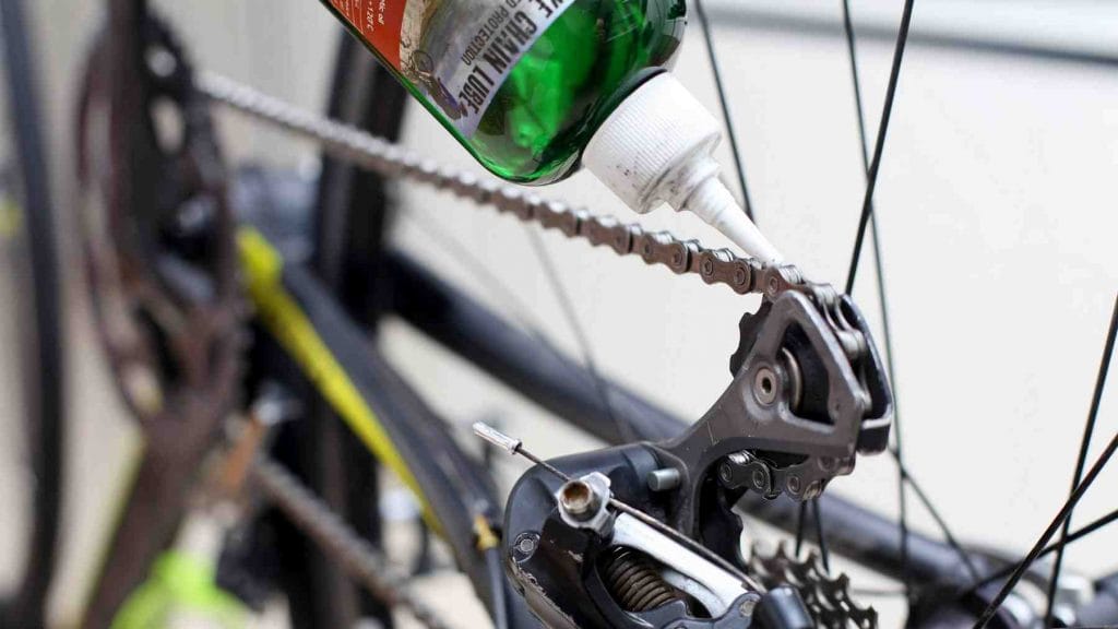 A picture of a bike chain being lubricated.