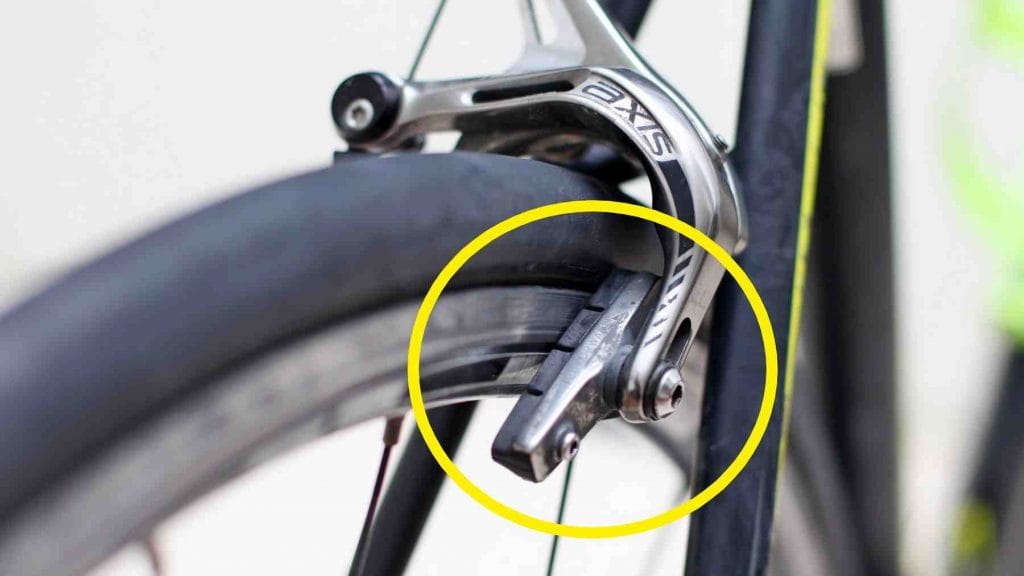 A picture of a misaligned brake pad on a bicycle wheel.