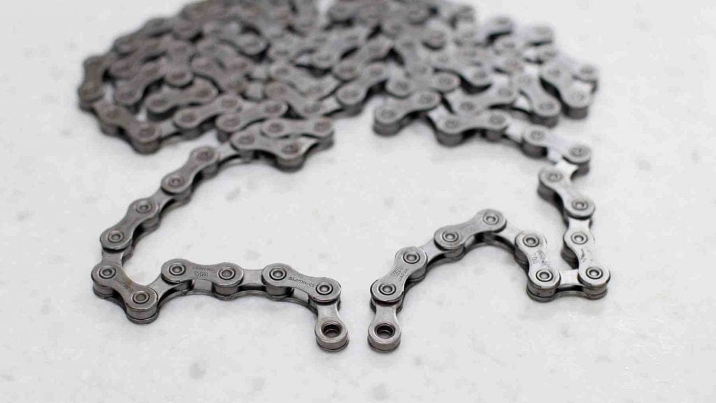 A picture of a bicycle chain with two inner plate ends.