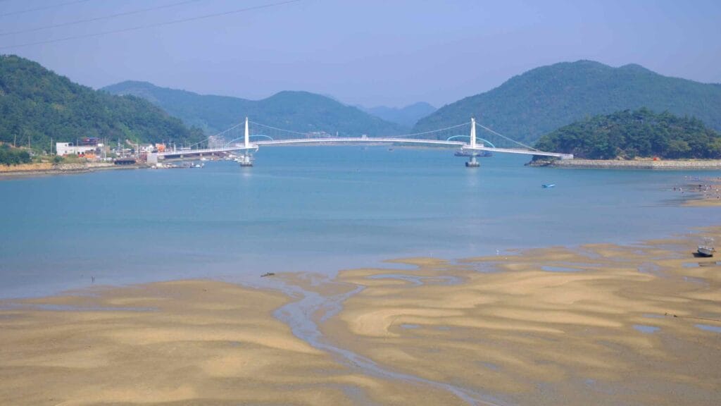 A view of the Haemaji Bridge stretching across the Seomjin River during low tide.
