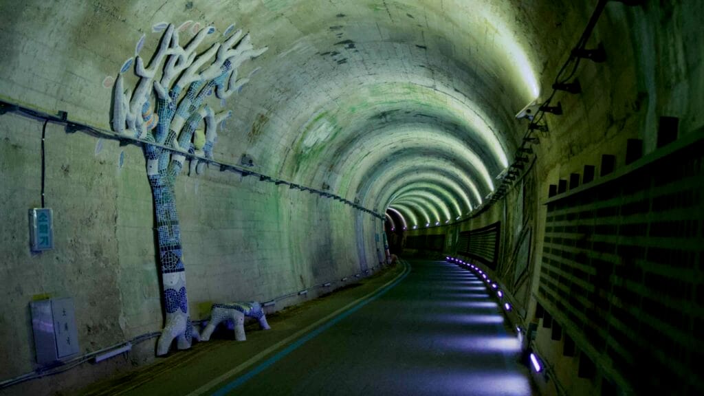 LED lighting and a mosaic tree sculpture create an atmospheric scene inside Hyangga Tunnel.