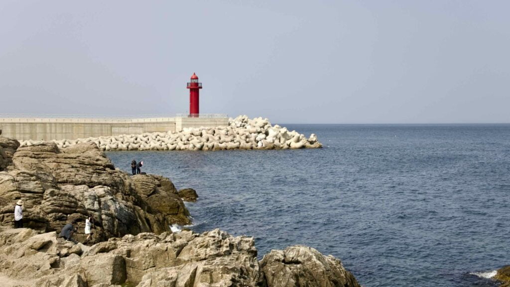 A picture of the red lighthouse sits at the end of Chuksan Port's breakwater in Yeongdeok County, South Korea.