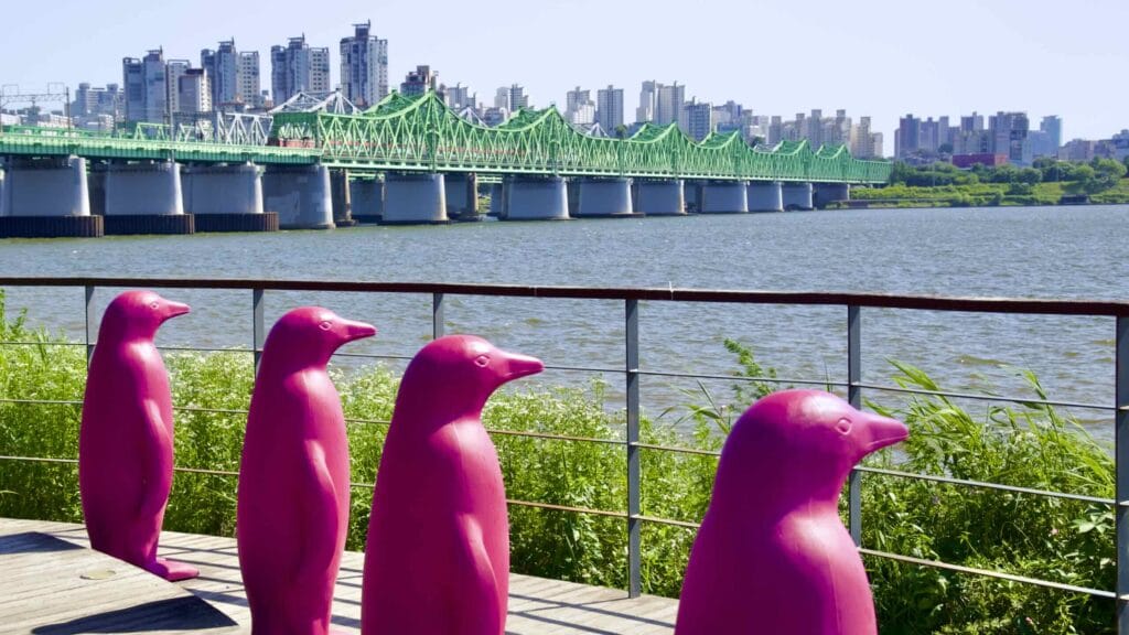A picture of the Cracking Art installation at Hangang Art Park and the Hangang Railway Bridges (한강철교) between Yongsan and Dongjak Districts in Seoul, South Korea.