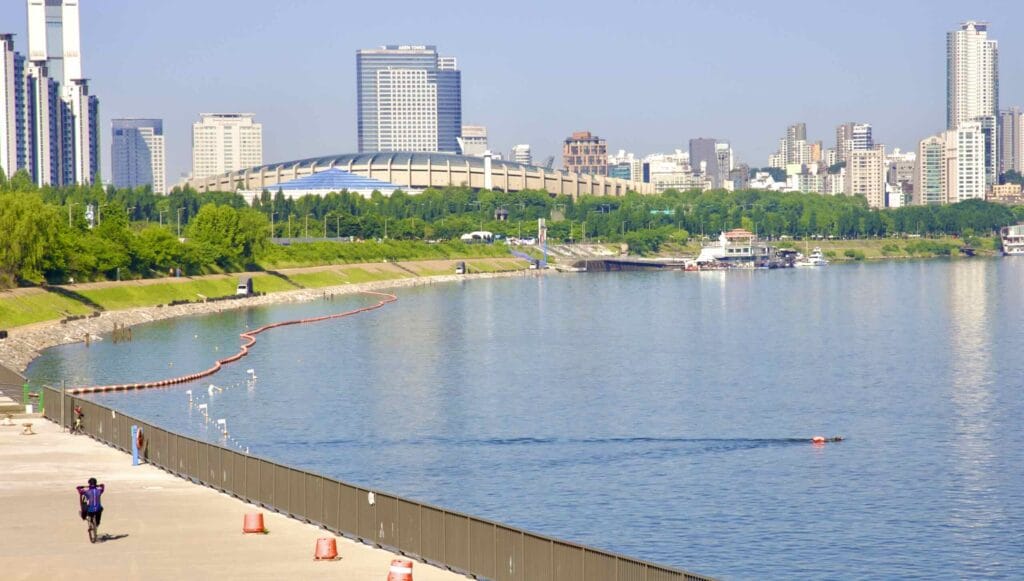 A picture of the Jamsil Sports Complex (잠실종합운동장) and the Gangnam District's skyline near Jamsil Hangang Park (잠실한강공원) in Seoul, South Korea.