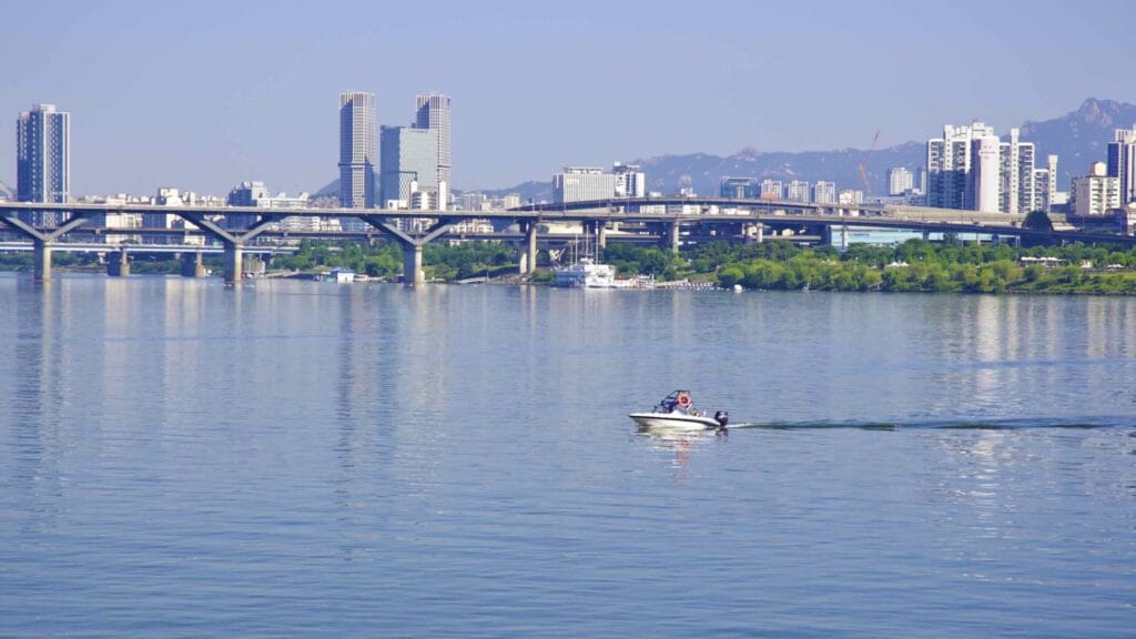 A boat crosses the wide Han River between Jamsil and Ttukseom Hangang Parks in Seoul, South Korea.