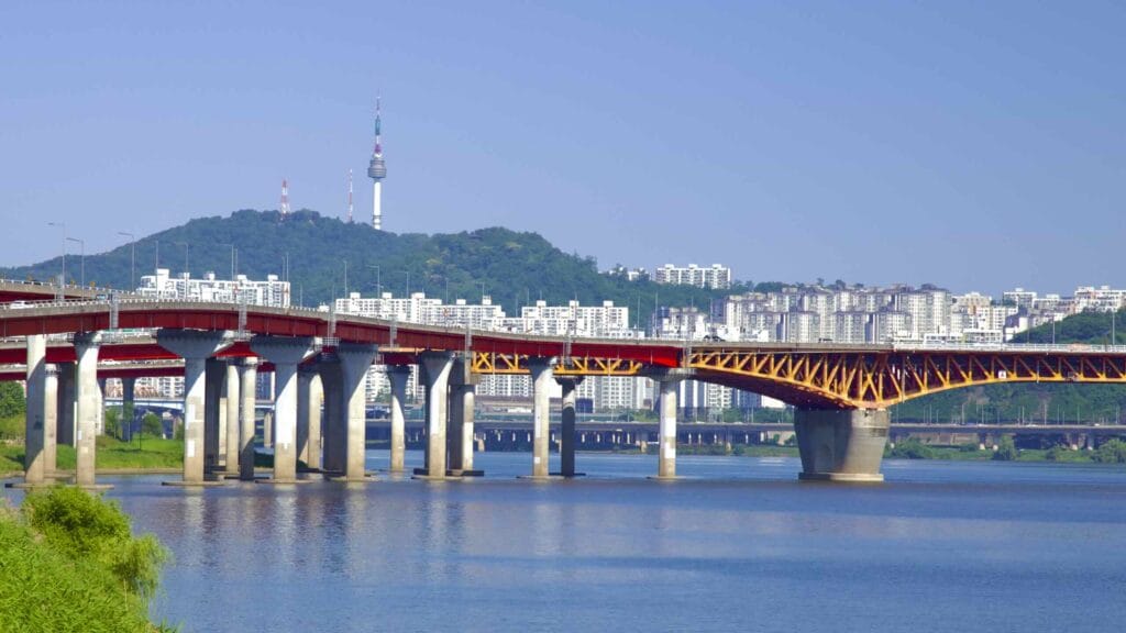 A picture of Seongsu Bridge (성수대교) and Namsan Mountain and Tower in Jamwon Hangang Park (잠원한강공원) in Seoul, South Korea.