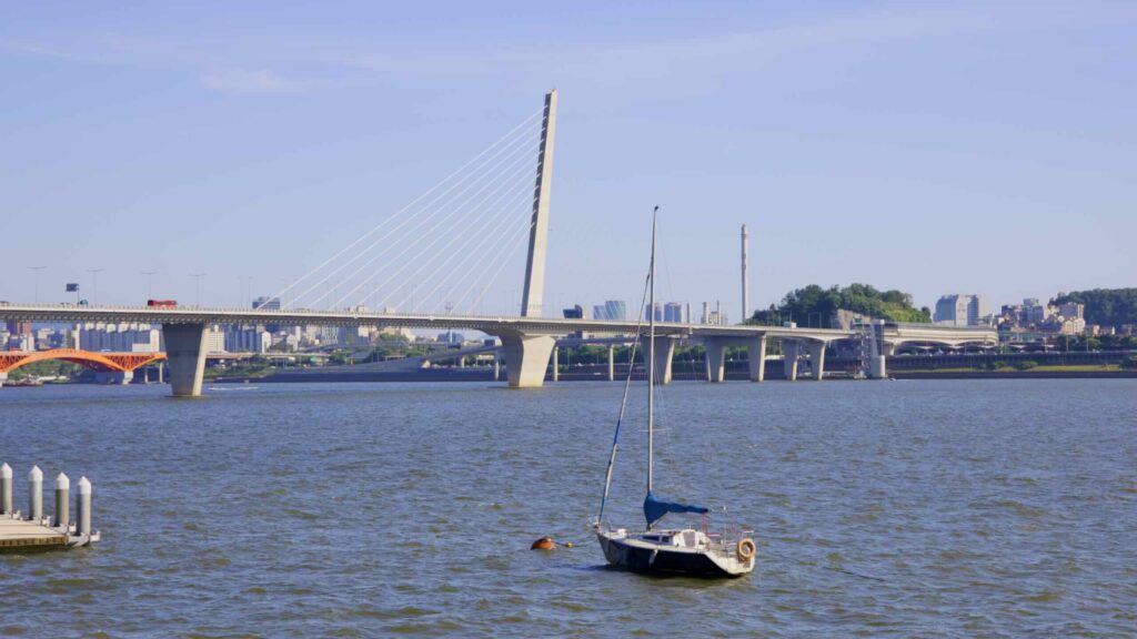 A picture of a sailboat and World Cup Bridge in Nanji Hangang Park (난지한강공원) in Seoul, south Korea.