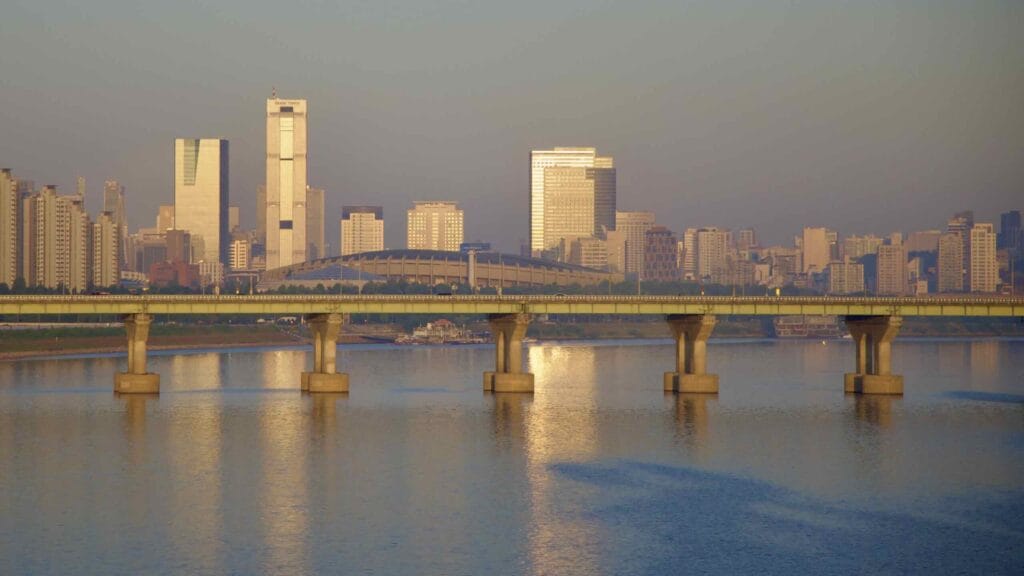 A picture of the Jamsil Sports Complex (잠실종합운동장) near Jamsil Hangang Park (잠실한강공원) and the Gangnam District's skyline in Seoul, South Korea.
