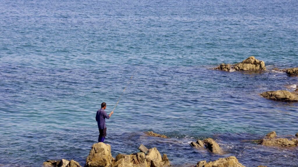 A picture of a fisher near Jukbyeon Coast Skyrail (죽변해안스카이레일) on Jukbyeon Cape (죽변곶) in Jukbyeon Port (죽변항) along the Gyeongbuk (East Coast) Bicycle Path (동해안자전거길 (경북)) in Uljin County (울진군), South Korea.