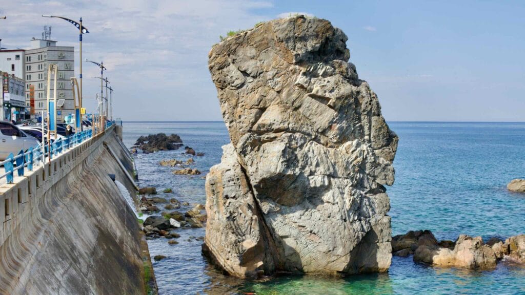 The imposing Black Rock, standing 15 meters tall off the coast of Mukho Port in the East Sea, earns its name from a legend of a crow laying its chick upon it.