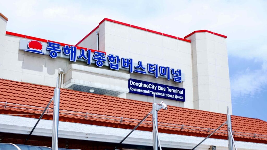 A detailed view of the multilingual sign atop the Donghae City Bus Terminal, showcasing Korean, English, and Russian languages.