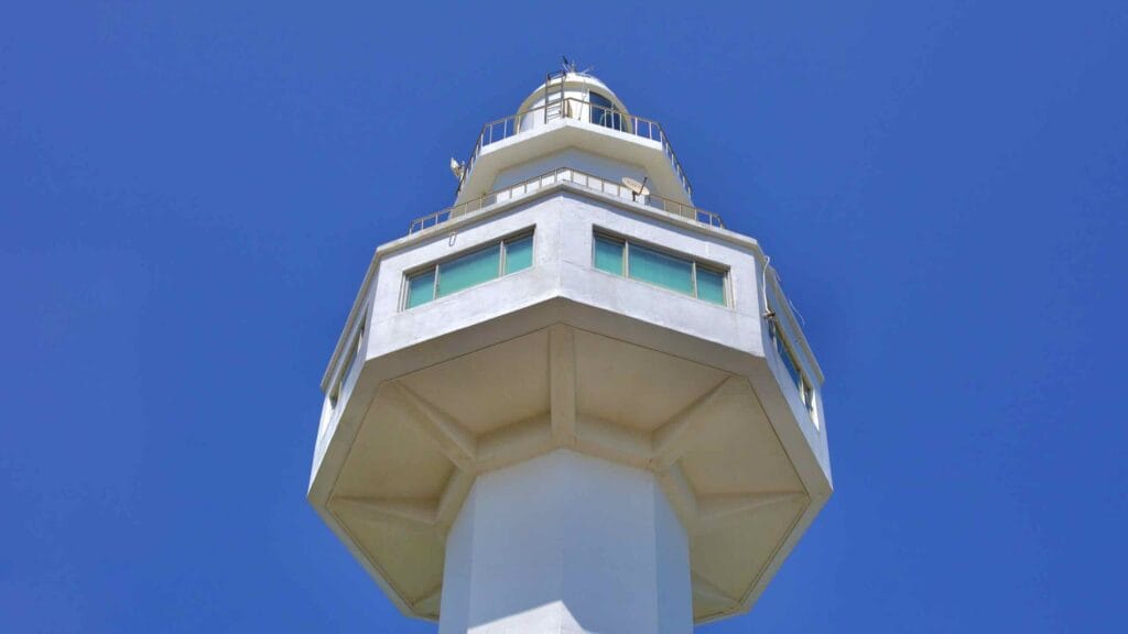 The towering white Daejin Lighthouse reaches into the blue sky, its octagonal structure standing 31 meters tall.