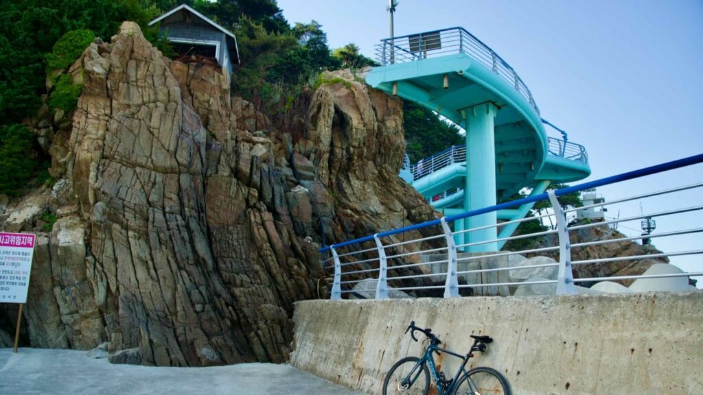 A bicycle parked at the base of the stairs leading to Jeongdong Simgok Sea Fan Road.