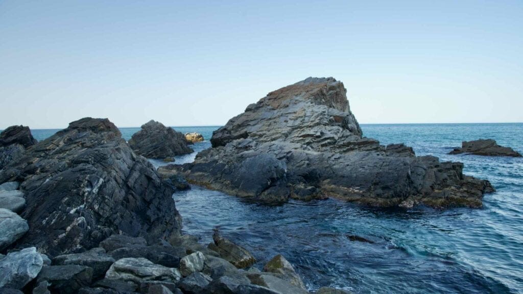Craggy rock formations rise from the waters of the East Sea near Heonhwa Road.