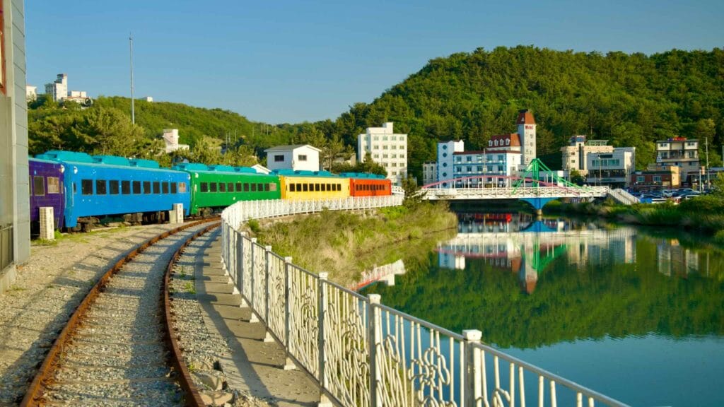 The rainbow-colored train cars, part of the Jeongdongjin Time Museum, wind along the track in Jeongdongjin.