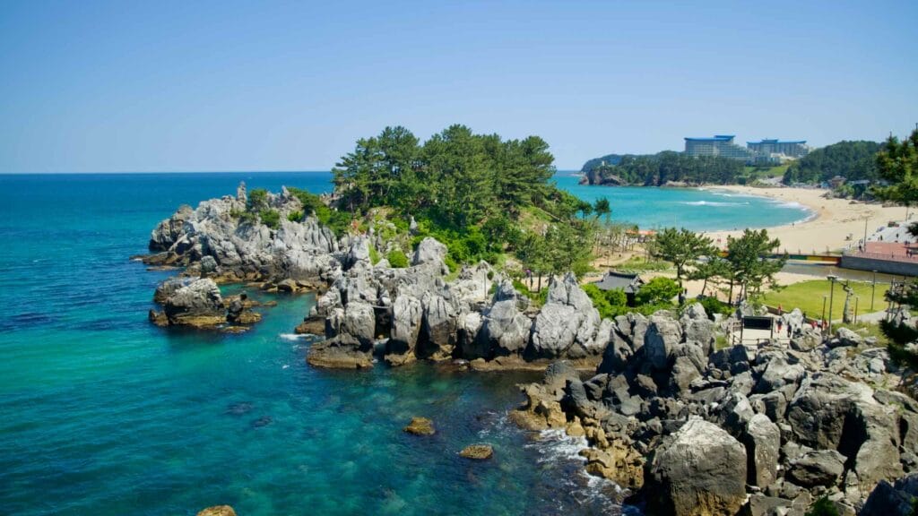 The coastal landscape of Chuam with its rocky outcrops leading to a sandy beach.