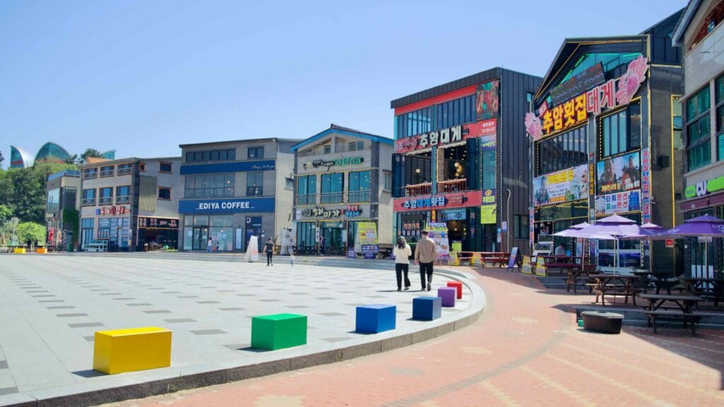 A square near Chuam Beach, featuring colorful restaurants and cafes.