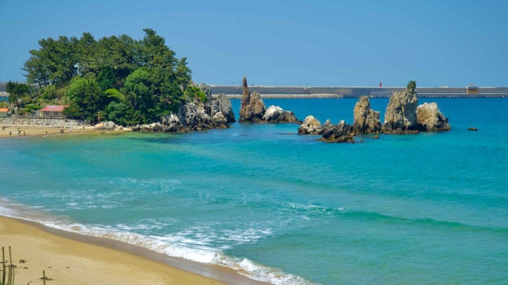 Chuam Candlestick Rock stands in the turquoise waters off Chuam Beach.