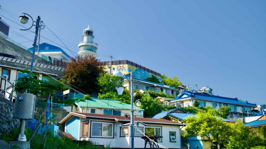 Mukho Lighthouse stands above the colorful rooftops of Nongoldam Street, highlighting the blend of maritime heritage and local architecture.