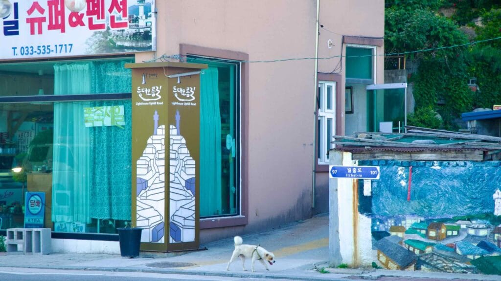 The entrance to Lighthouse Road, marked by signs and murals, leads to Nongoldam Street.