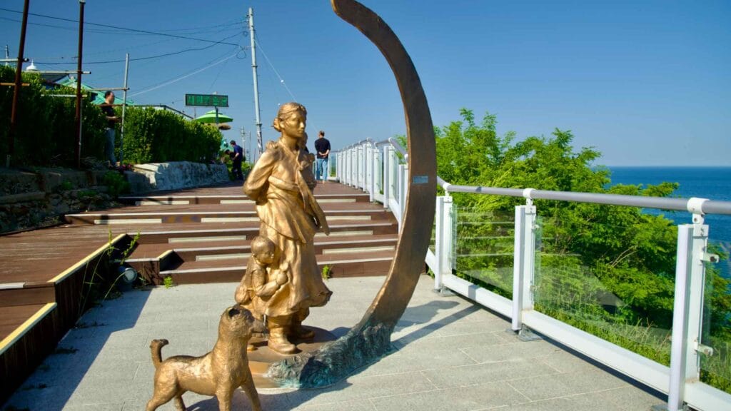 A statue depicting a family and their dog stands prominently on the Nongoldam Street observation deck.