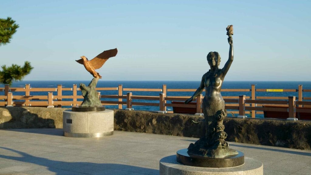 Bronze sculptures of a mermaid and a bird in the courtyard of Jumunjin Lighthouse.