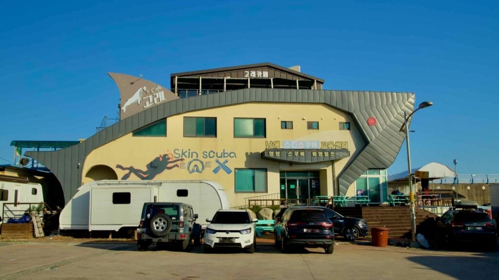 A unique marine center and cafe at Namae Port, designed with maritime-inspired architecture, serves as a hub for scuba training and refreshments.