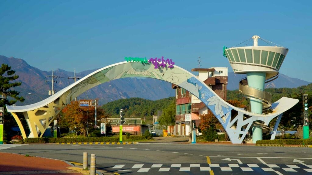 The scenic entrance arch to Seorak Sunrise Park, featuring vibrant artwork and a spiral observation tower with views of Seorak Mountain in the background.
