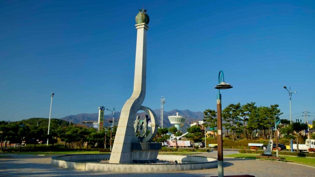 The Tower of Remembrance stands tall at the Plaza of Unity in Seorak Sunrise Park, symbolizing the hope for Korean reunification, with Seorak Mountain as a scenic backdrop.