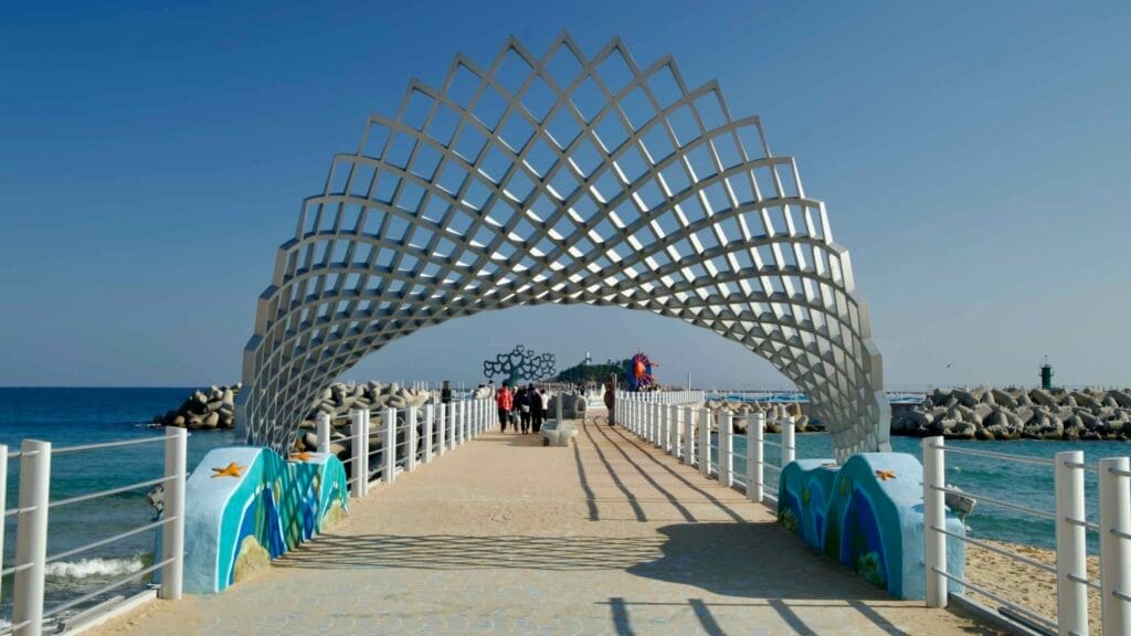 A striking sculpture marks the entrance to the breakwater at the northern end of Sokcho Beach, offering a scenic view of Jodo Island and the East Sea.