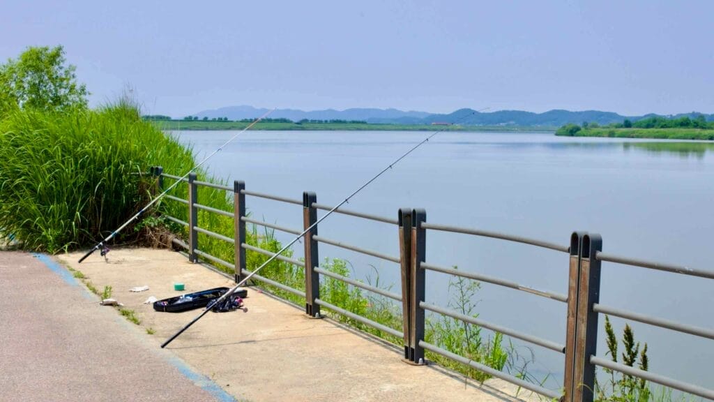 Fishing rods rest against a railing along the Geum River near Ganggyeong Port.