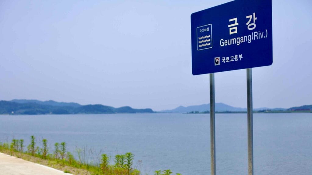 A sign marking the Geum River (Geumgang) stands beside a smooth cycling path, offering riders a