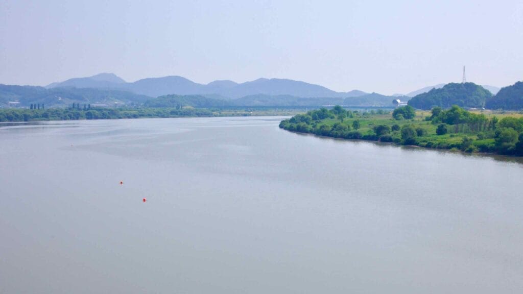 A stretch of the Geum River flows past green riverbanks.