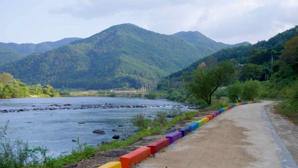 Scenic and safe, a colorful bike path follows the Seomjin River through green mountains.