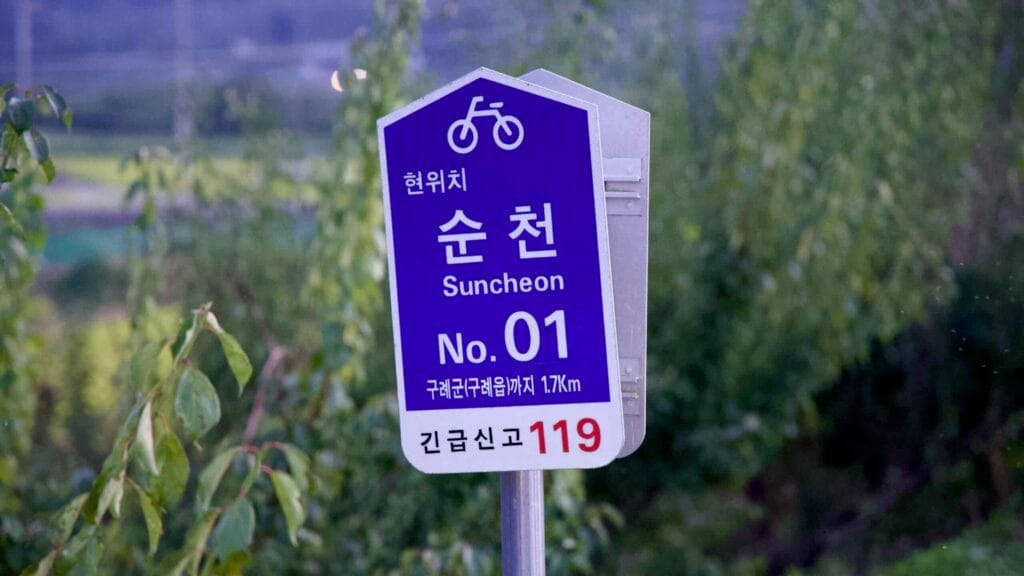 Seomjingang Bike Path sign near Suncheon, guiding cyclists on the scenic riverside route.