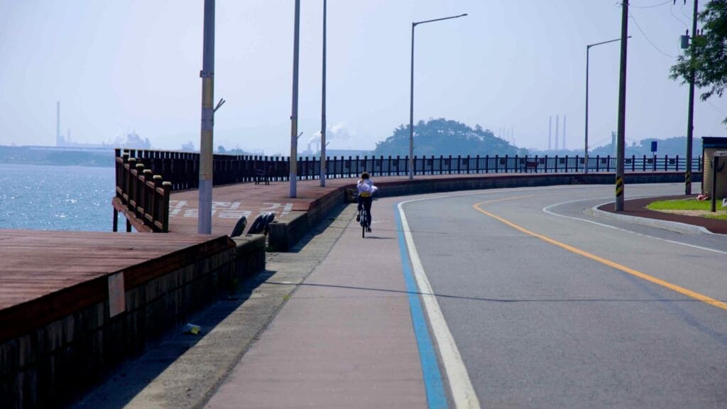 A cyclist rides along a designated bike path near Mangdeok Port's boardwalk on the Seomjin River.