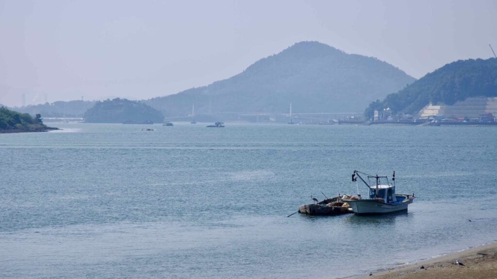 A fishing boat floats near the mouth of the Seomjin River as it flows into the South Sea.