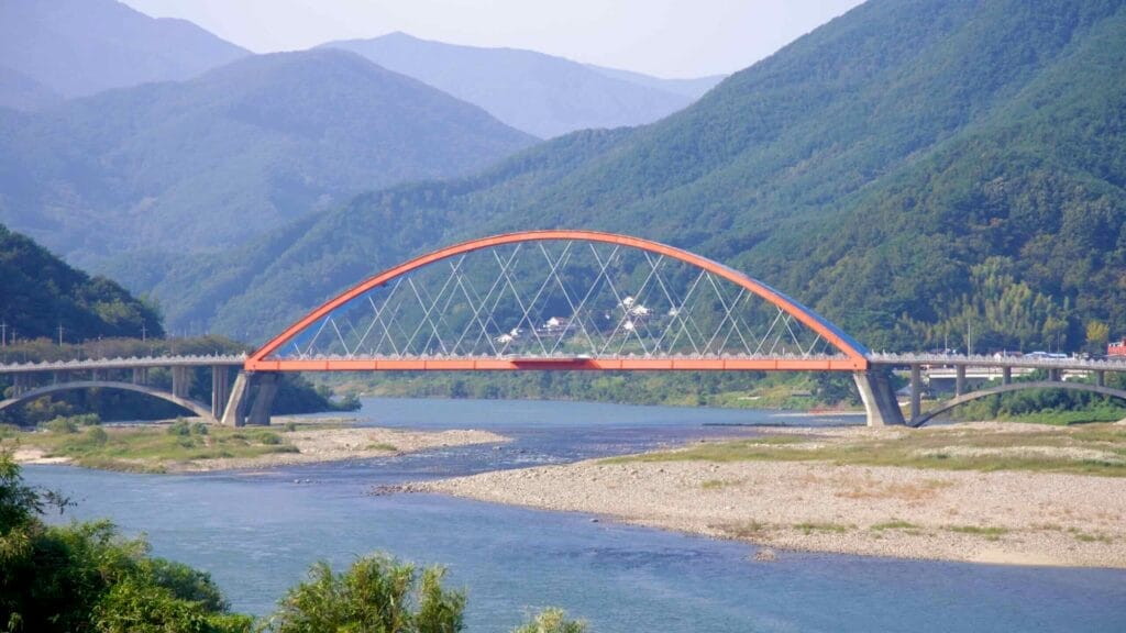 Namdo Bridge, with its red and blue arches, stretches across the Seomjin River.