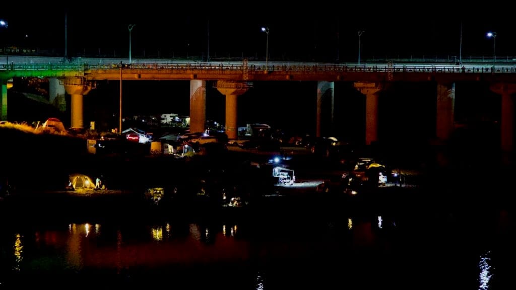Night view of Apnok Resort on the Seomjin River, with glowing tents under the bridge.