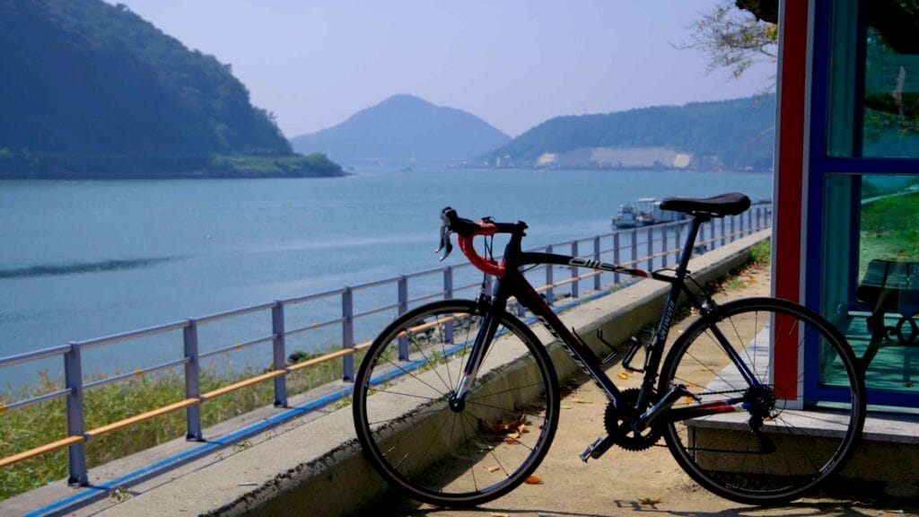 A road bike leans against a shelter along the Seomjingang Bike Path, overlooking the Seomjin River.