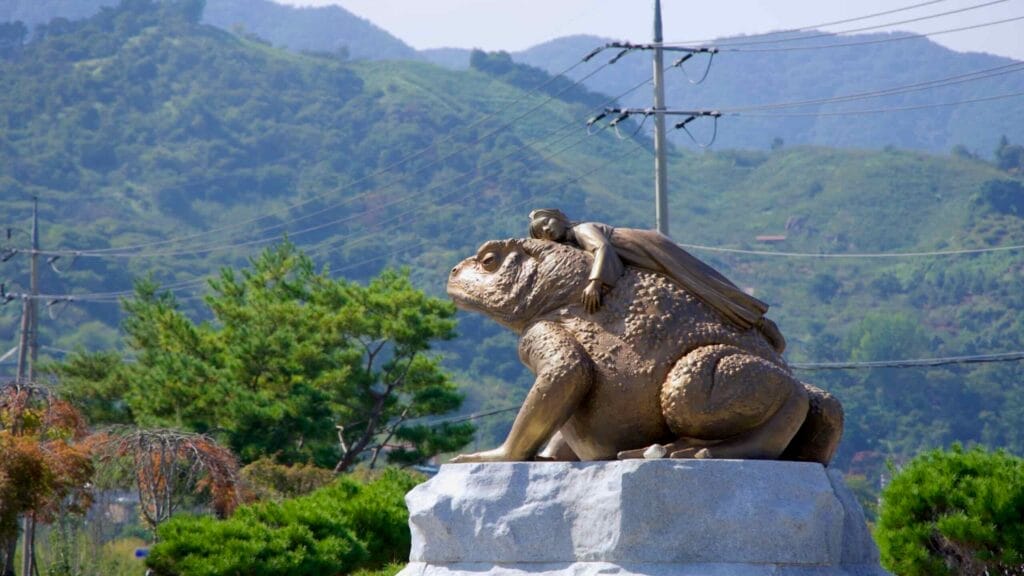 A statue depicting a giant toad with a figure resting on its back, commemorating the legend of the Seomjin River.
