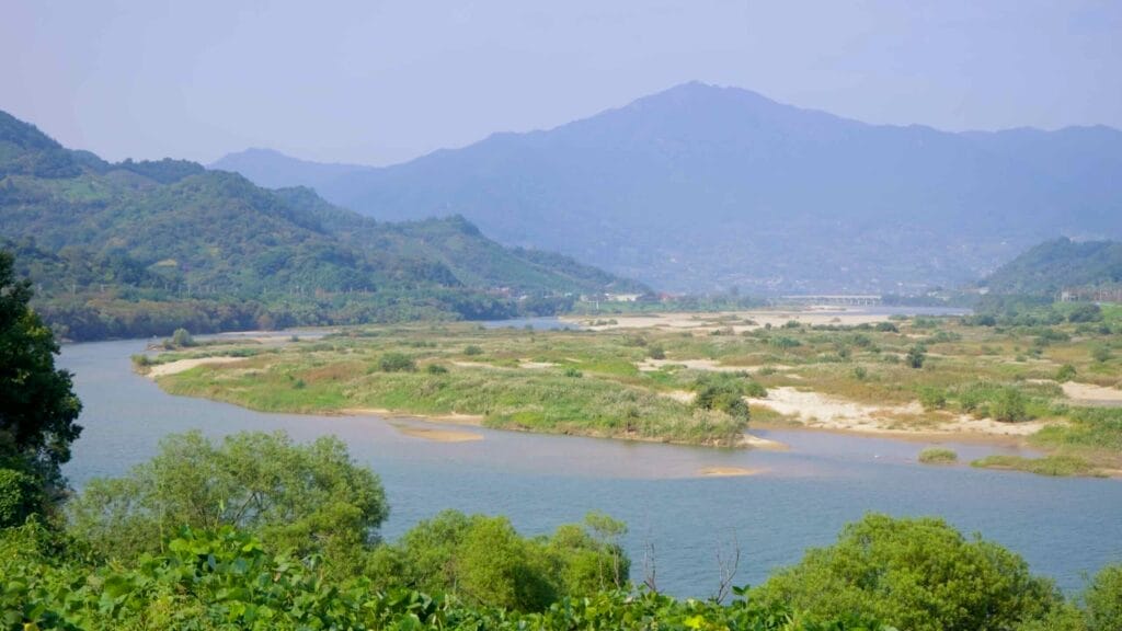 A view of the Seomjin River winding through wetlands, with sandbanks and vegetation.