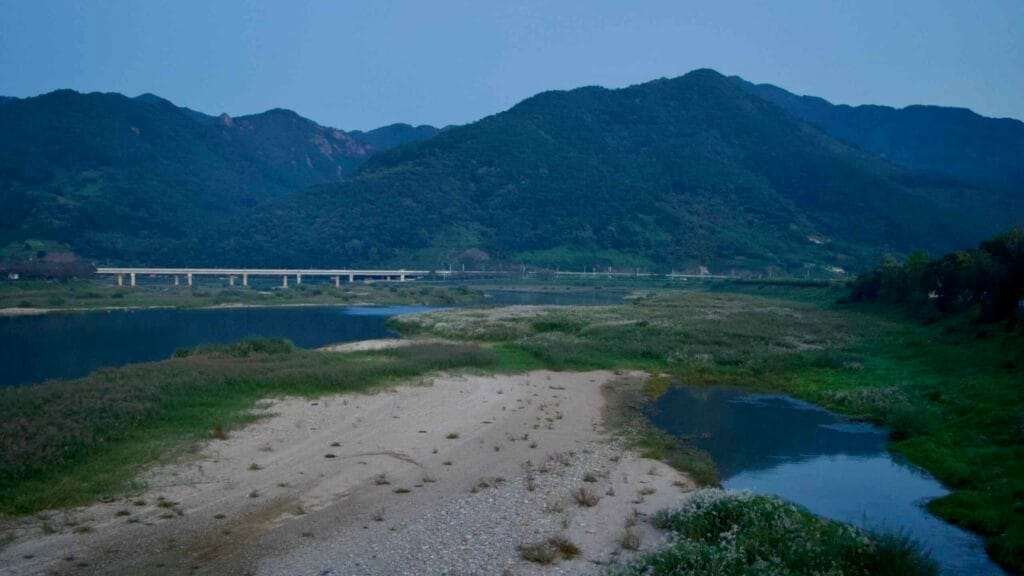 Twilight settles over the Seomjin River valley, showcasing its sandy riverbank.