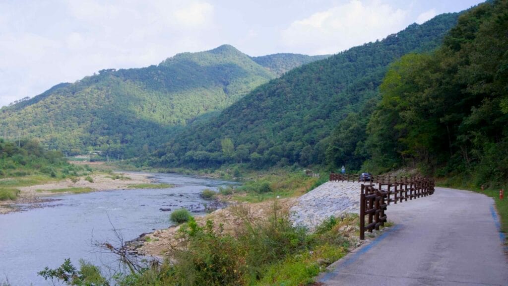 Seomjingang Bike Path curving along the Seomjin River with mountain views.